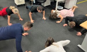 BUSY Marketing team in circle doing pushups