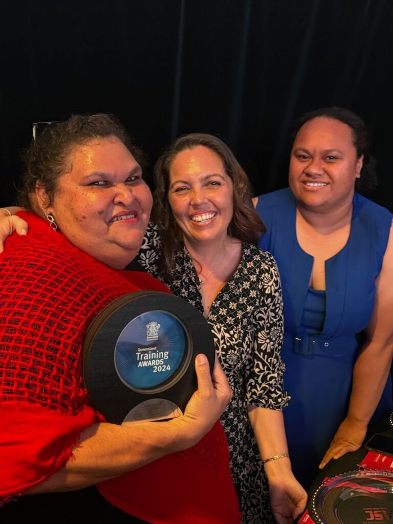 Three women, one receiving award for Queensland Training Awards 2024 FNQ Equity Student of the Year