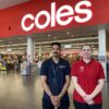 Young woman with male recruitment worker standing in front of Coles supermarket