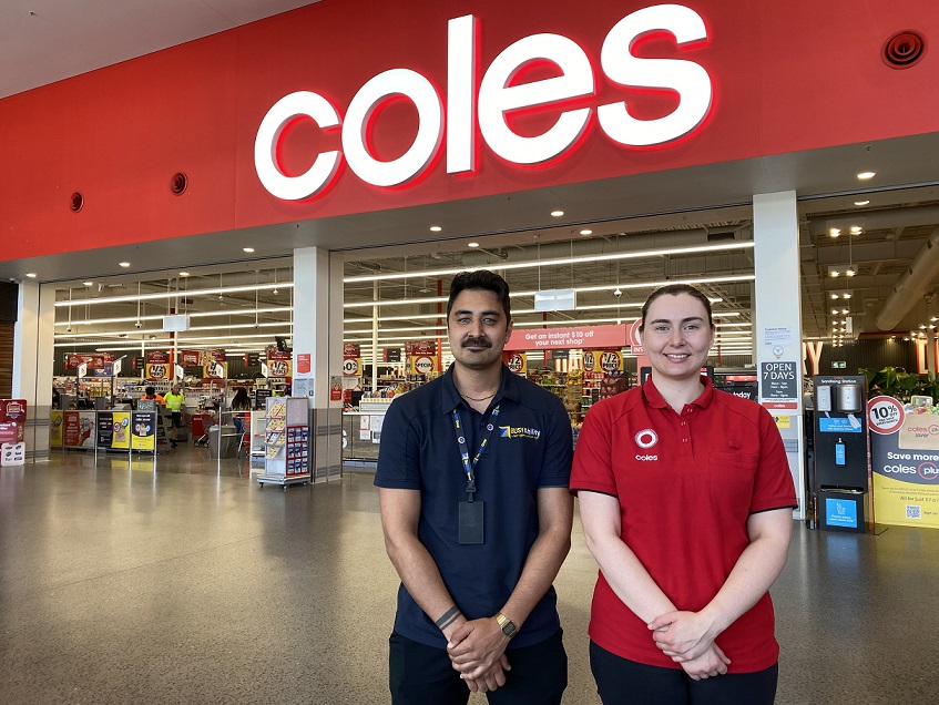 Young woman with male recruitment worker standing in front of Coles supermarket